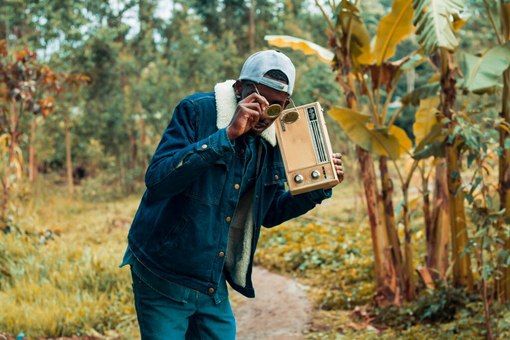 Stylish man with a retro radio in a lush forest setting in Kiambu, Kenya.