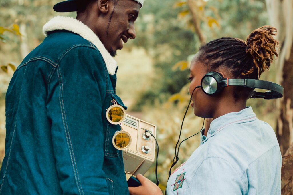 Two people enjoying a vintage radio experience outdoors in Kiambu, Kenya.